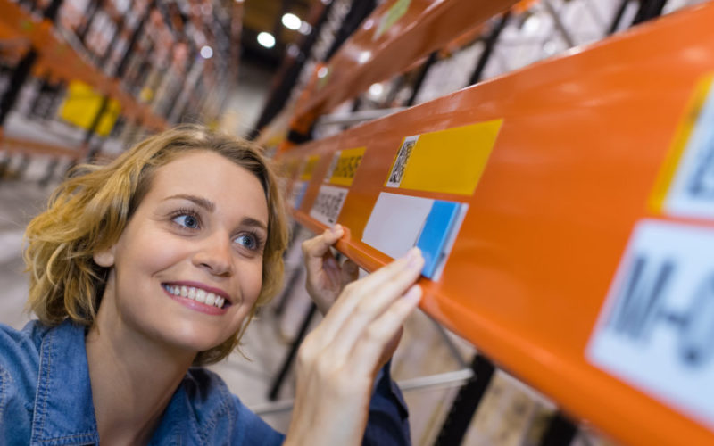 etiquette entrepot happy warehouse worker putting prices on shelves
